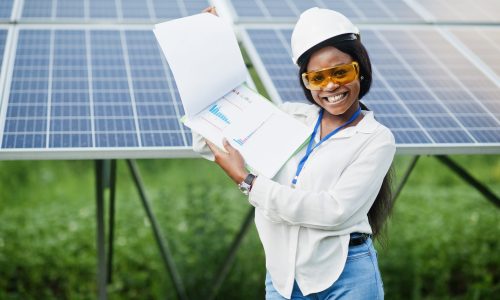 African american technician check the maintenance of the solar panels. Black woman engineer at solar station.
